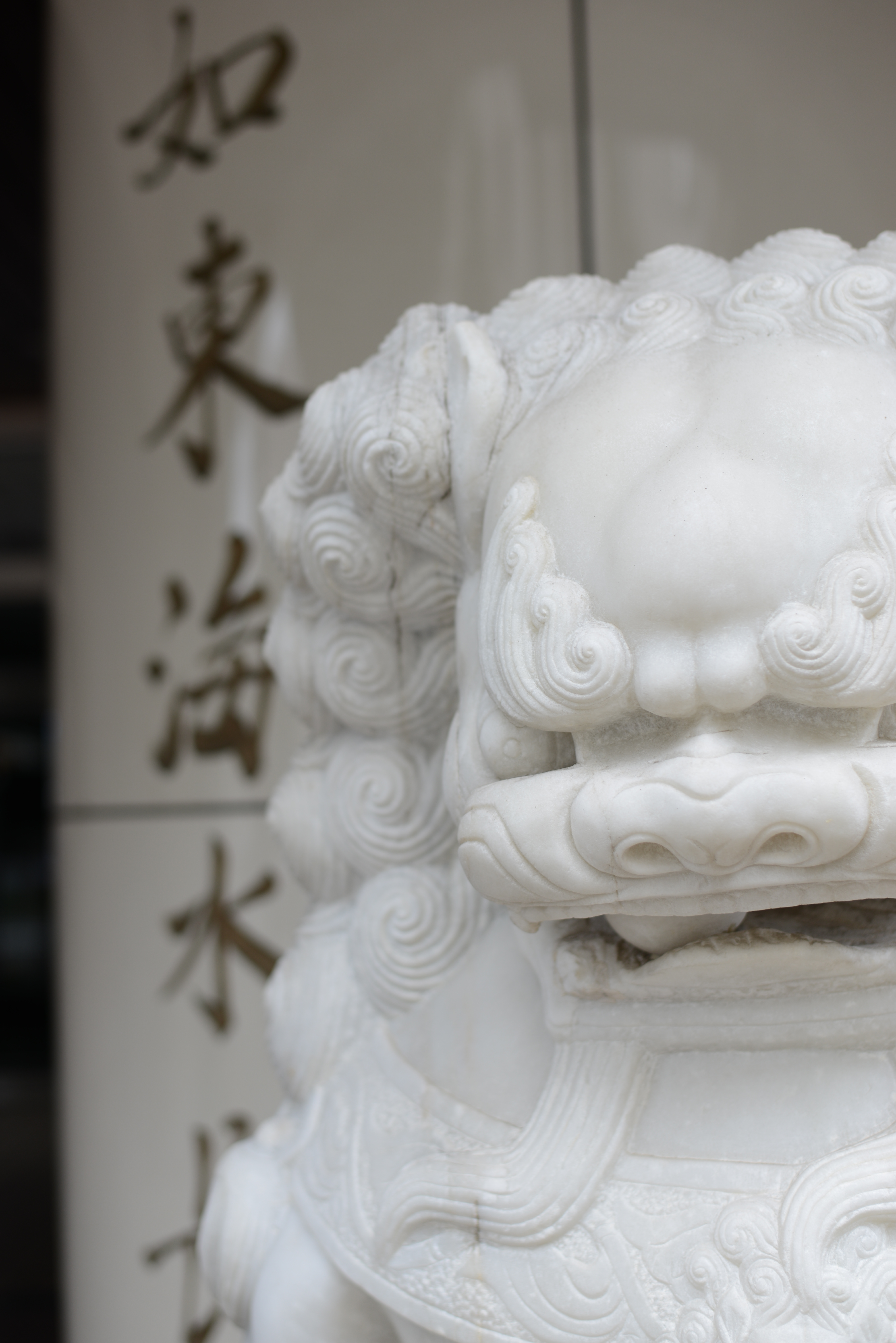 <b>集合住宅らしい建物のエントランスになぜか狛犬。D600 / AF-S 50mm F1.8 G / 6,016×4,016 / 1/100秒 / F2.8 / 1.0EV / ISO100 / WB:AUTO1</b>