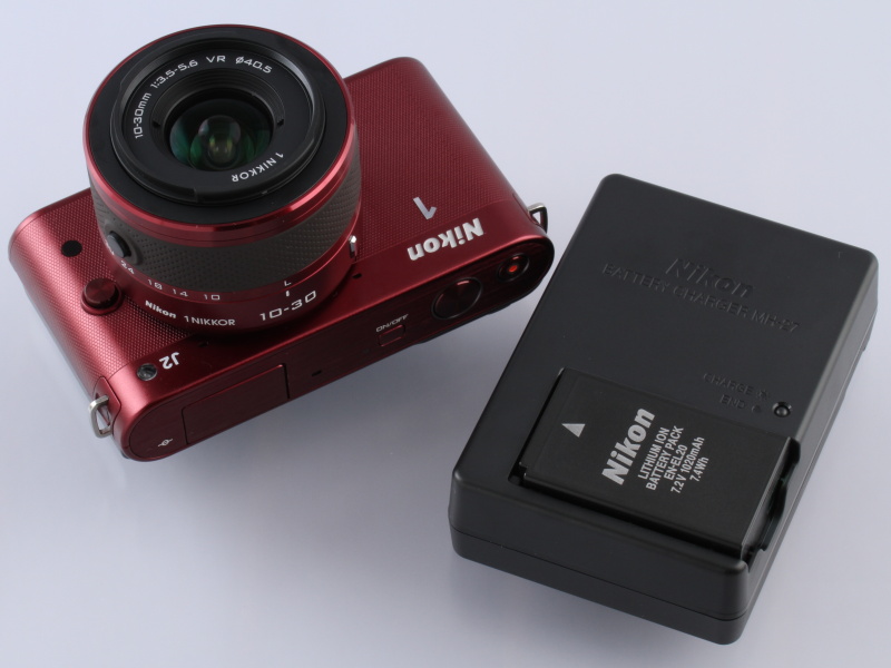 <b>ボディと変わらないボリュームの充電器が同梱される。旅先などへの携行を思うと、小型化やmicroUSB充電への対応が望まれる</b>