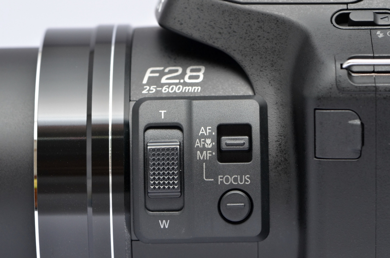 <b>鏡筒横にはサイドレバーを装備。前モデルDMC-FZ150にも装備されていたが、DMC-FZ200ではサイズが大きくなり、操作性がより向上している、とのこと。初期設定ではズームの機能が割り当てられているが、セットアップメニューのサイドレバー設定により、MF時のピント合わせやAF時（半押し状態）のピント微調整などが行なえる。</b>