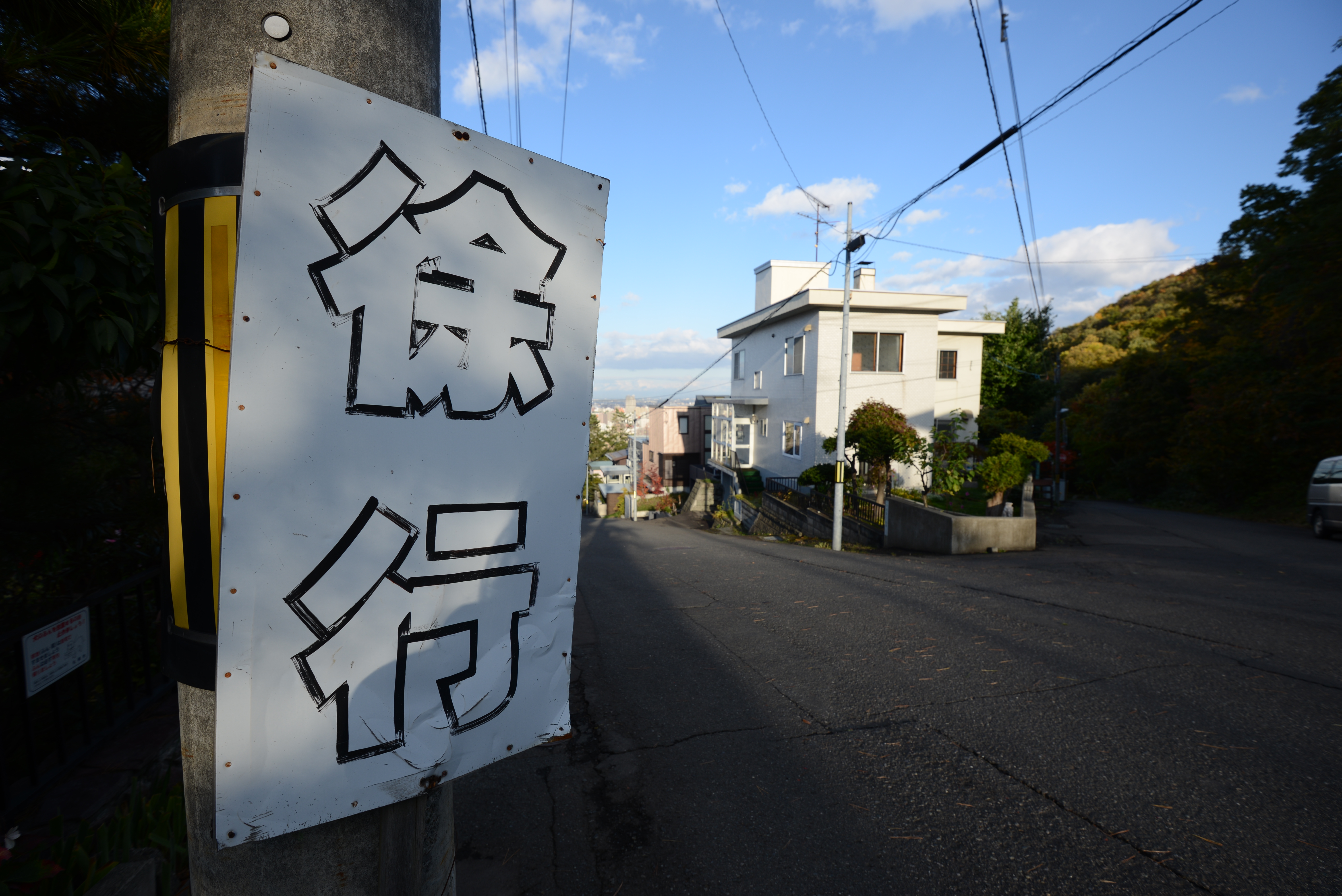 <b>山の中腹の住宅街だけに、急な坂が多くて、それが冬には凍結するわけで、だからあちこちに「徐行」を促す看板がある。D600 / AF-S NIKKOR 16-35mm F4 G ED VR / 6,016×4,016 / 絞り優先AE / 1/200秒 / F6.3 / 0.3EV / ISO100 / WB:晴天 / 16mm</b>