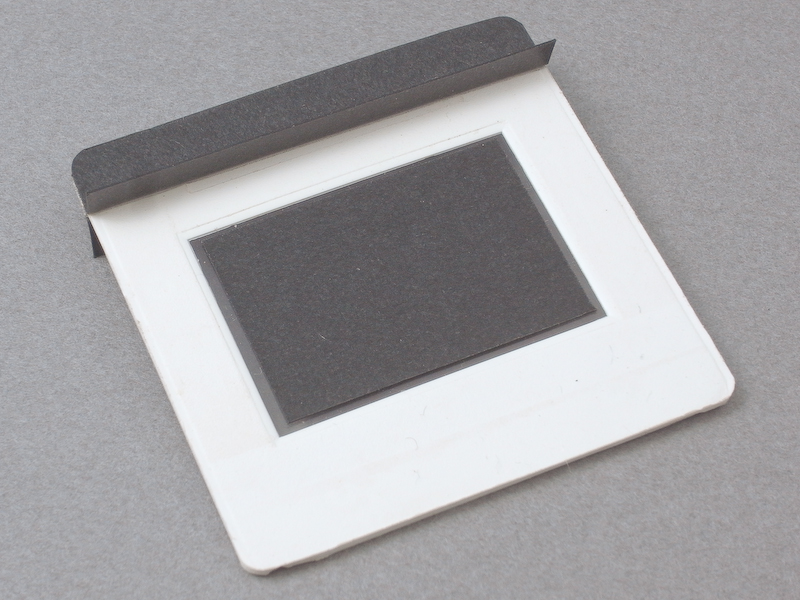 <b>そこで、黒ケント紙をL字に折った遮光パーツを製作し、スクリーン上部に両面テープで貼り付けた</b>