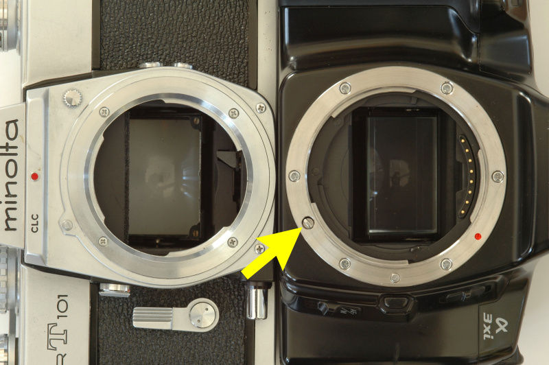 ミノルタMCマウント(左)とミノルタαマウント(右)。同じような三本爪のバヨネットマウントだが口径が大型化し、ボディ内のAFモーターの回転力を伝えるカップリング（矢印）と電気接点が加わっている。
