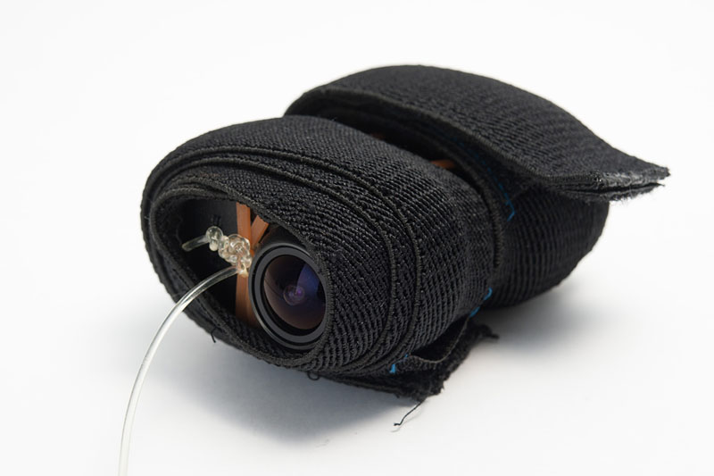 アクションカムに透明の紐を付け、マジックテープ付きのゴムバンドを2本巻く。落とした場合のクッションにもなる。