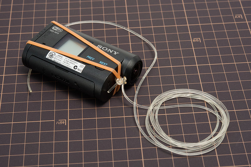 ゴムバンドを外すとこんな状態になっている。輪ゴムに透明の紐が付いている。これはシリコン製なので、伸縮するのだが、釣りに使うテグスの方が入手しやすいだろう。