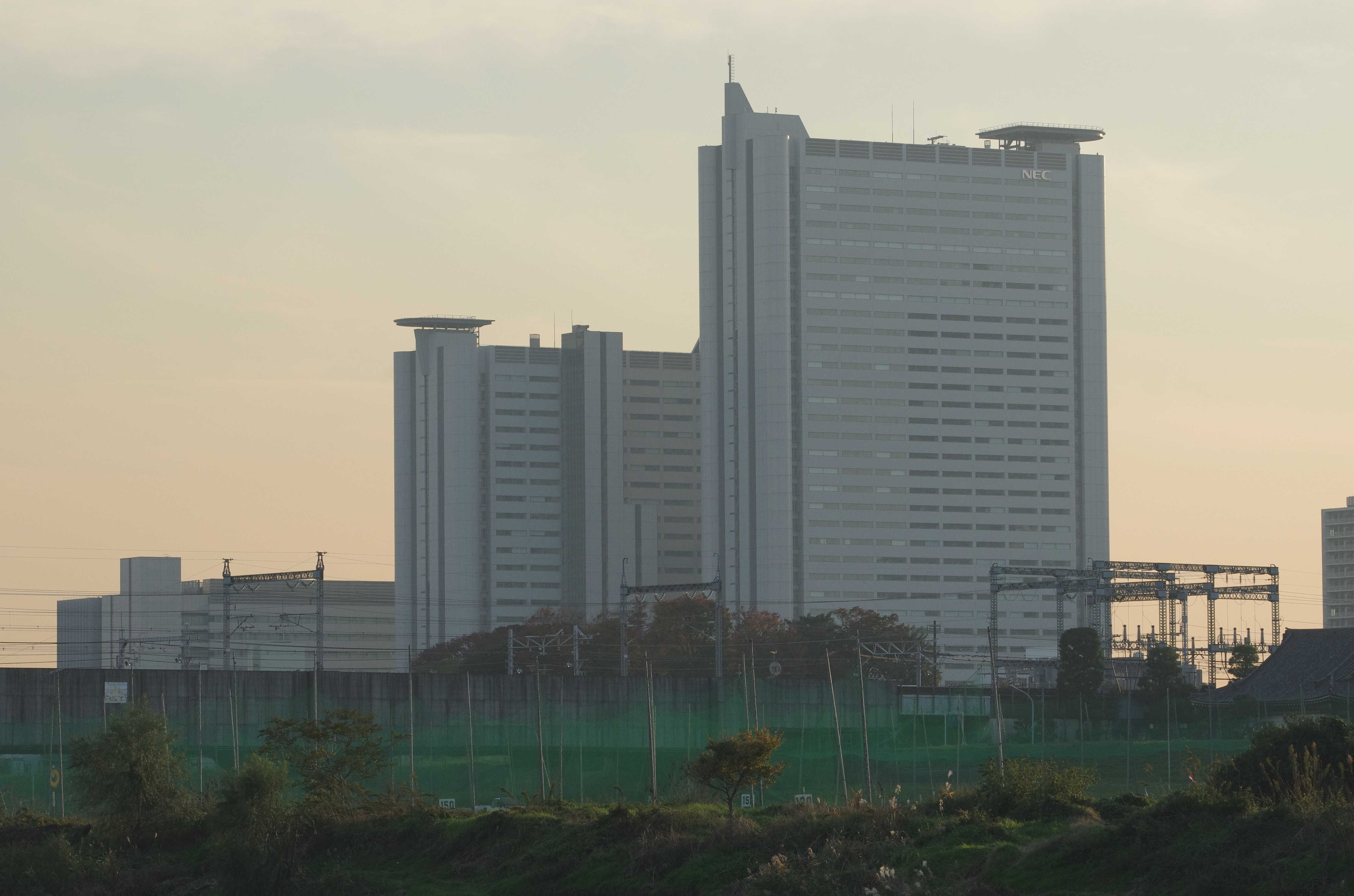 夕もやのかかる川越しの遠景でコントラストは下がっているが、ビルの企業ロゴの写りにローパスレスらしさを感じた。PENTAX K-5 IIs / DA★60-250mm F4 ED [IF] SDM / 約7.6MB / 4,928×3,264 / 1/1600秒 / F5.6 / 0EV / ISO800 / 絞り優先AE / WB：太陽光 / 108mm