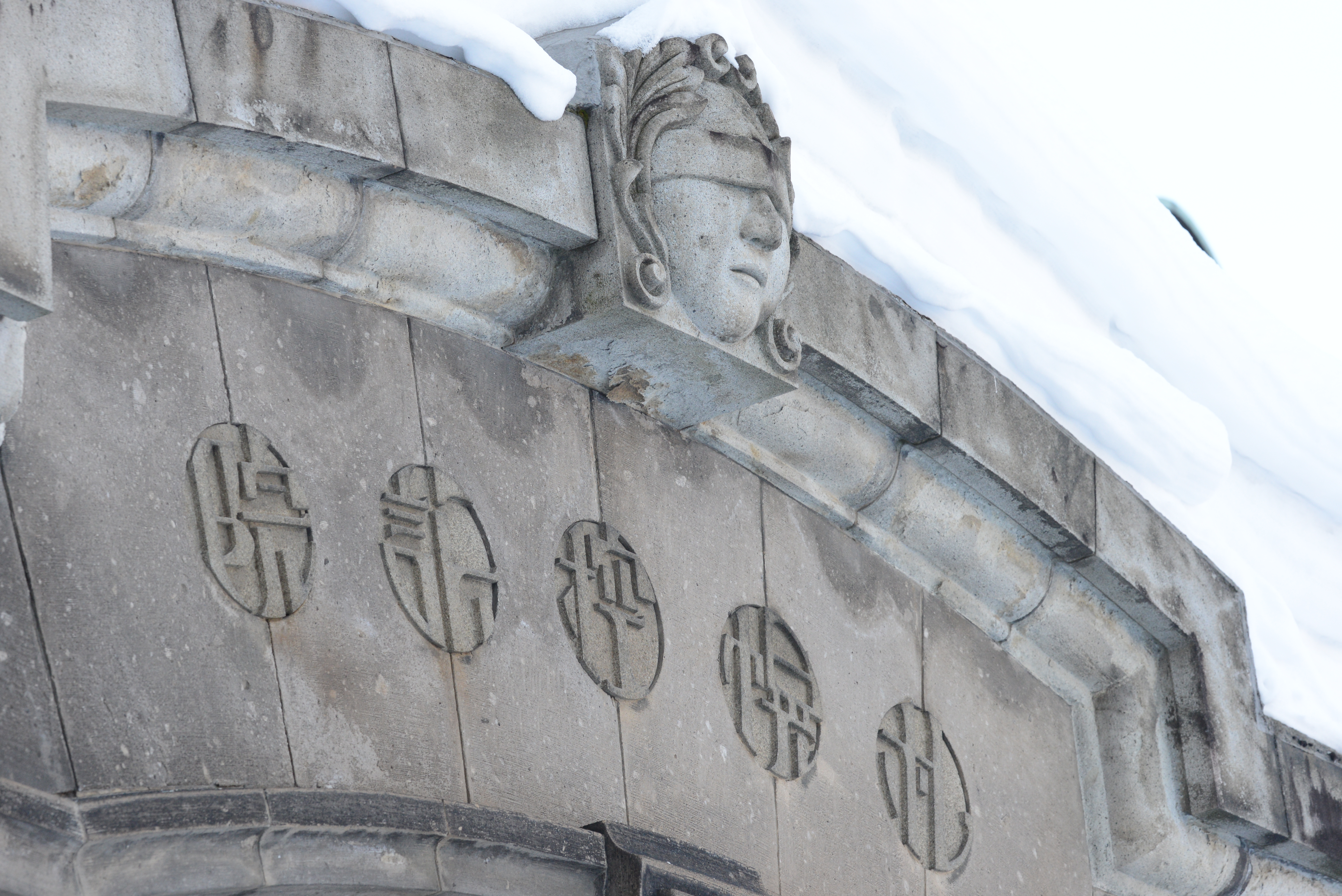 今の高等裁判所に相当する控訴院の建物がそのまま資料館になっている。目隠しをした顔の像はギリシャ神話の法の女神に由来するのだそうな。D600 / APO Macro 150mm F2.8 EX DG OS HSM / 6,016×4,016 / 1/320秒 / F8 / 0.3EV / ISO1250 / WB：オート2 / 150mm