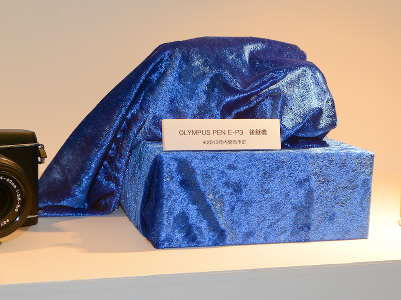 オリンパスブースには「E-P3後継機」が布をかぶった状態で展示。