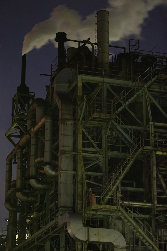 工場の配管や階段などがおりなすさまざまな線を画面に点光源が入らないように望遠で切り取りました。あえて暗めに露出補正しISO6400の高感度で背後にある蒸気の形も再現。