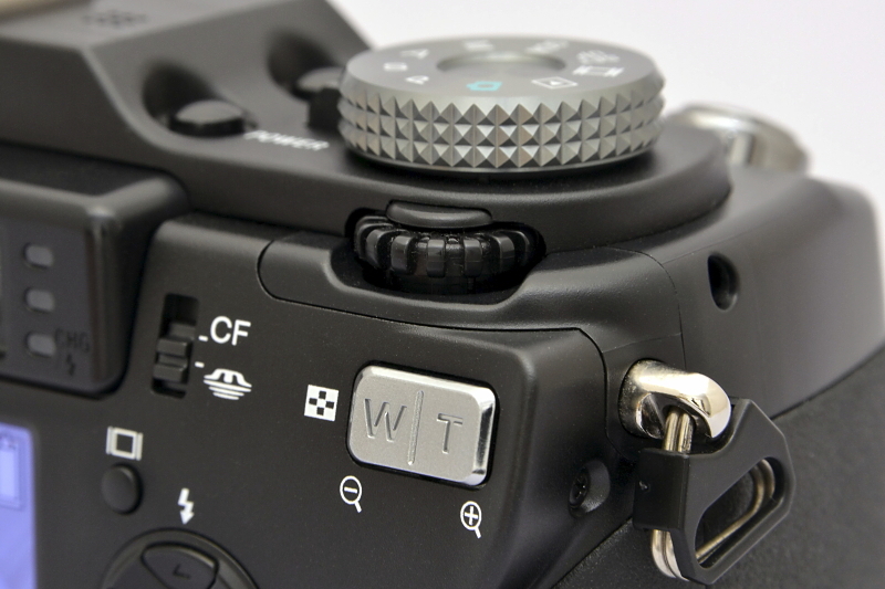 大型のモードダイヤルの下（背面側）にはジョグダイヤルがある。シャッター速度や絞り値や露出補正値などは、このダイヤルを回転させたり押すことで、項目を選んだり数値を変えることができる。MF時の設定値（距離）も、このダイヤルの回転によって操作する。