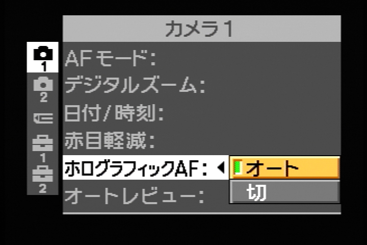 モードダイヤルを「SET UP」にして「ホログラフィックAF」をオートに設定すると、暗い場所でシャッターボタン半押し時に、レーザーホログラムによるAF補助光が照射される。では、半押しを……おわっ!? こ、この照射光のパターン、何だか兵器っぽくてびびった。