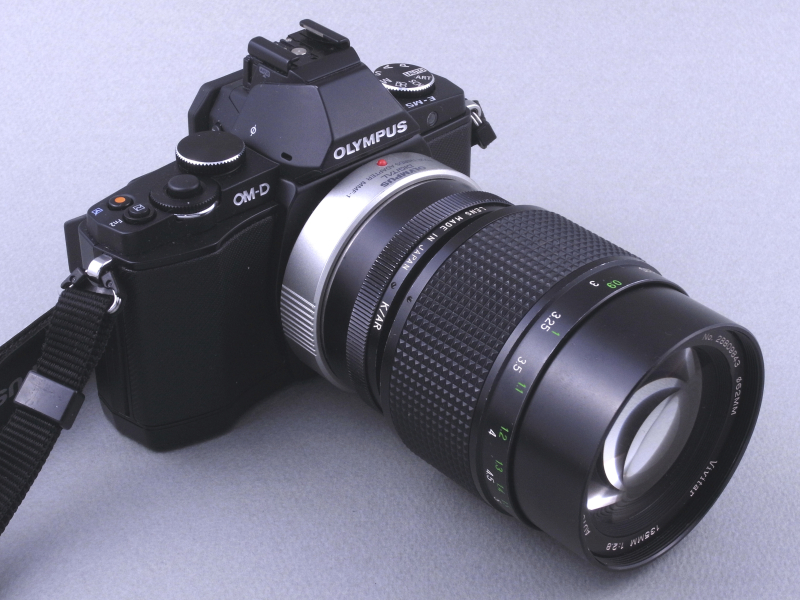 E-M5にVivitar 135mm F2.8 Close Focusを装着したところ。ライカ判換算270mm相当の望遠マクロになる。改造ARマウントレンズはあくまでフォーサーズマウントに装着可能なので、E-M5に装着する場合は「MMF-1」などのフォーサーズアダプターを介して行なう。ずいぶん大きなレンズのように思えるが、それだけE-M5が小さいカメラなのだ。