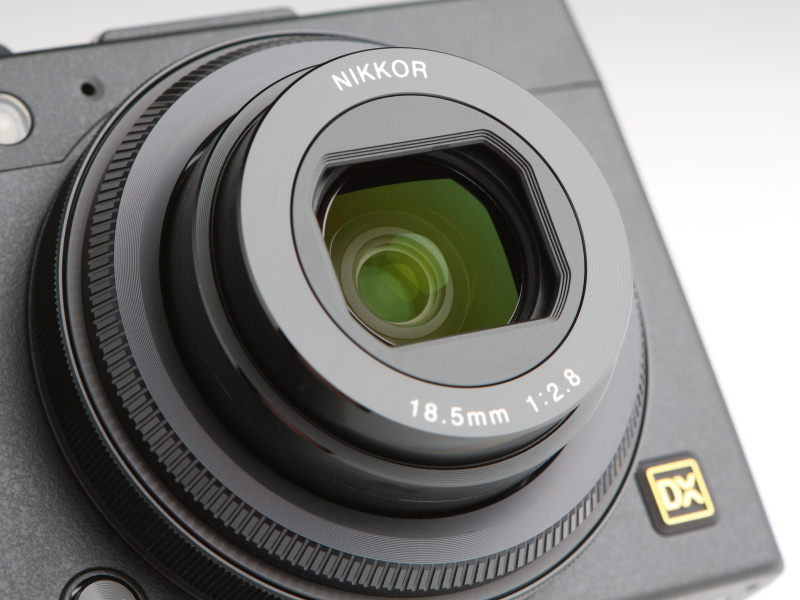 レンズは約28mm相当の「NIKKOR 18.5mm F2.8」を搭載する。鏡筒は沈胴式で、このクラスには珍しくレンズバリアも備えている。