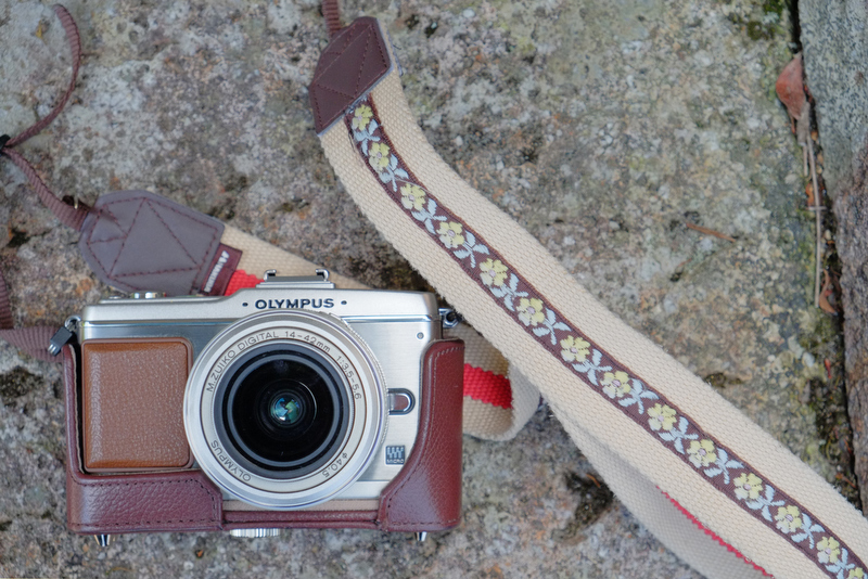 カメラ女子たちのカメラは見ているだけでとてもカワイイ♪ こちらはチロリアンテープを縫い付けた自作ストラップ。ちなみに参加者が持ってきたカメラの割合は、一眼レフカメラが9名、ミラーレスカメラが21名。