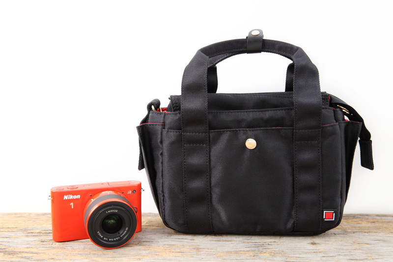 今回使ってみたのが写真のバッグ、3WC-PR011のブラック（1万7,850円）。見た目はとてもシンプルですが、カメラが好きな女性が使いやすいような機能がたくさん詰まっています。