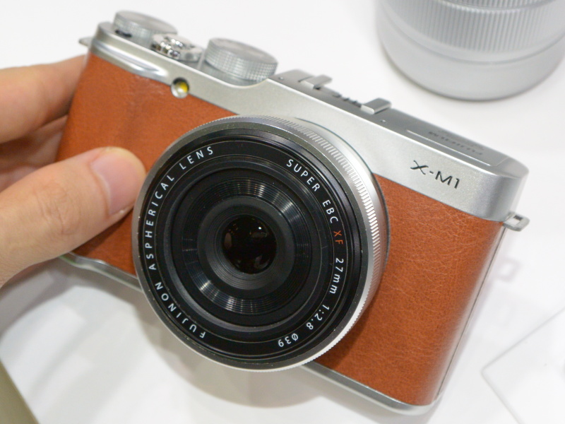 FUJIFILM X-M1（ブラウン）にシルバーのXF 27mm F2.8を装着したイメージ。ブラウンのみ発売日が遅く、今回の展示もモックアップだった
