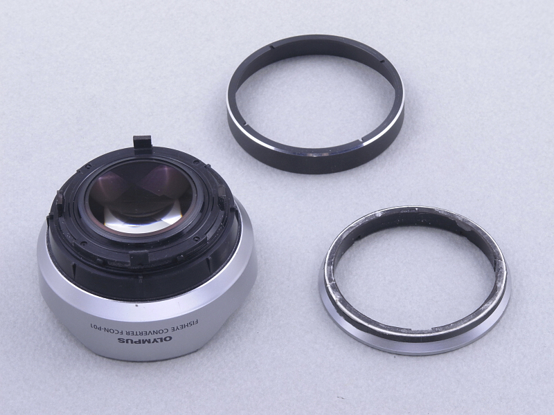 ばらけてしまったパーツを検証すると、レンズ本体（左）は化粧リング（中）を挟んで、マウントパーツ（右）に3本の爪で固定されていたようだ。そして、ぼくがマウントパーツを削ったためにレンズ本体の固定爪も削れてしまい、分解してしまったのた。だから本来は、レンズ本体の固定爪を外せば、レザーソーでカットせずともコンバーターは分解できたのだった。