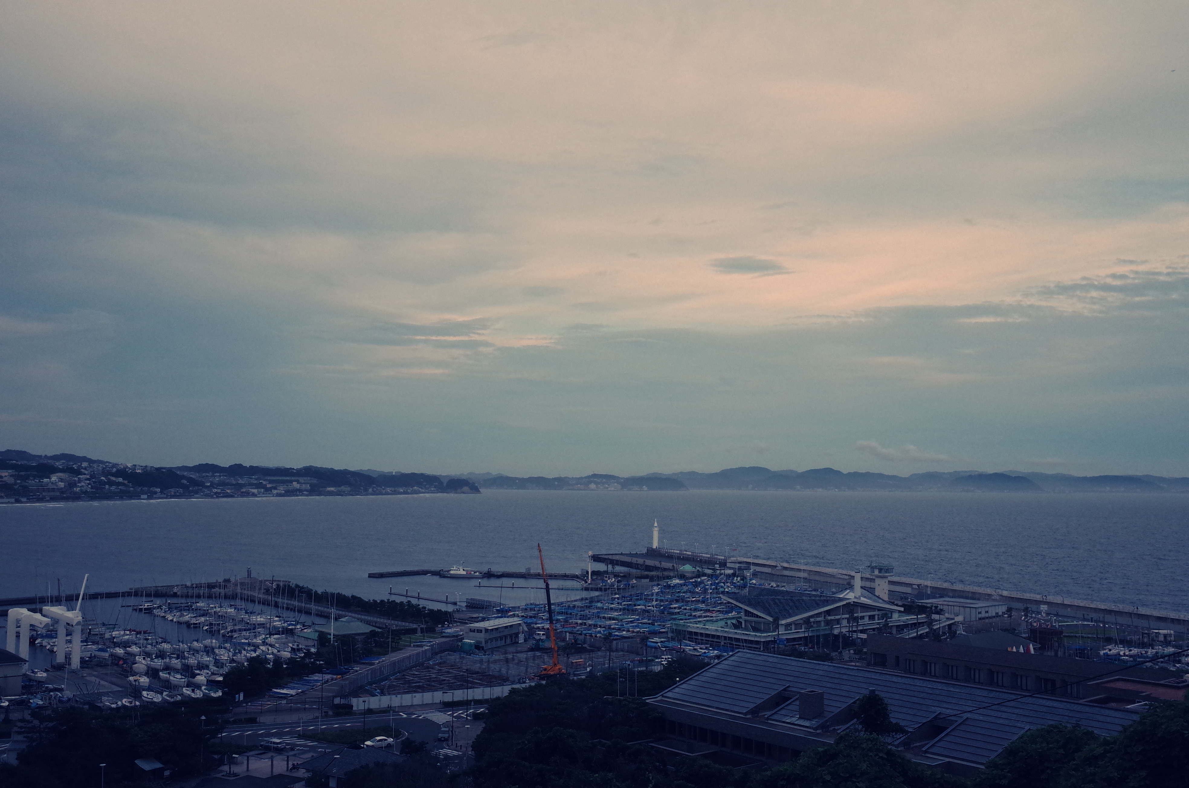この島に来るのは小学生の時以来、たぶん2度目。エスカレーターは途中で外に出て、また乗り継ぎになります。港を一望できる場所にたどり着きました。ここまで、お天気は、あまり良くありませんでした。「クロスプロセス」で撮影。1/1500秒 / F2.8 / -0.3EV / ISO400 / 絞り優先AE / WB：オート / 18.3mm（35mmクロップ）