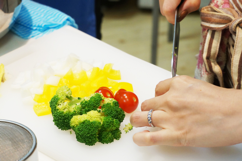 最初に用意された彩りのよいプチトマト、パプリカ、ブロッコリーなどの野菜を切ります。