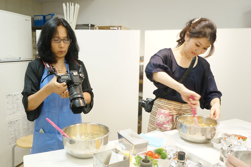 タマネギ、パプリカ、ブロッコリーをしんなりするまで炒め、粗熱を取ります。粗熱を取っている間に、ケークサレの生地を作ります。参加したカメラ女子は、自分のカメラで調理の手順も写真に収めていました。