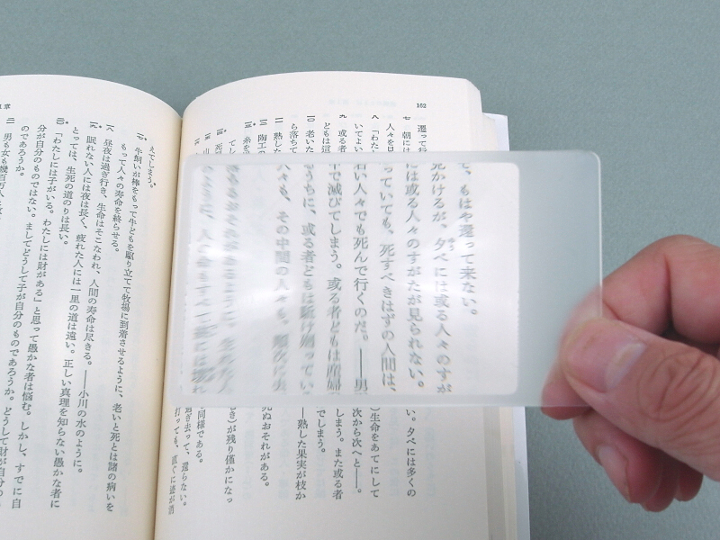 100円ショップで購入したフレネルレンズ。通常はカード型のルーペとして使用し、文庫本の文字も大きくして読める。