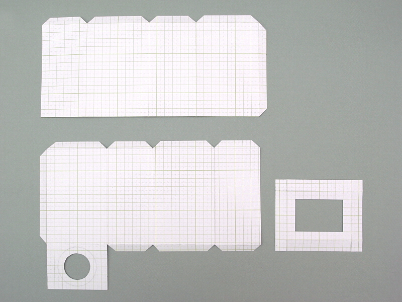 工作用紙からレンズ鏡筒のパーツを切り出す。工作用紙とは方眼が印刷されたボール紙で、画材屋さんで購入した。各パーツは鏡筒外側(上）、鏡筒内側(下左）、鏡筒先端（下右）という構成。