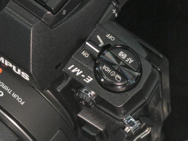 E-M1（左）の電源レバーやドライブボタンの部分は、M-1（右）などの電源レバーおよび巻き戻しノブをモチーフにしたデザインとなっている。