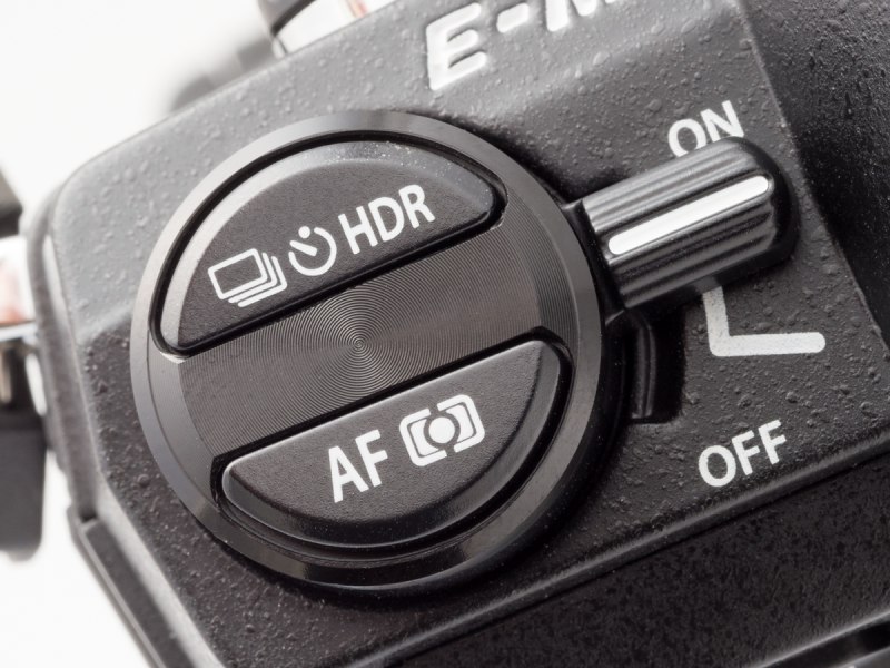 OM-1/2の巻き戻しノブの意匠をモチーフにしたドライブ/HDRボタンとAFモード/測光モードボタン。メインスイッチのレバーも懐かしい。