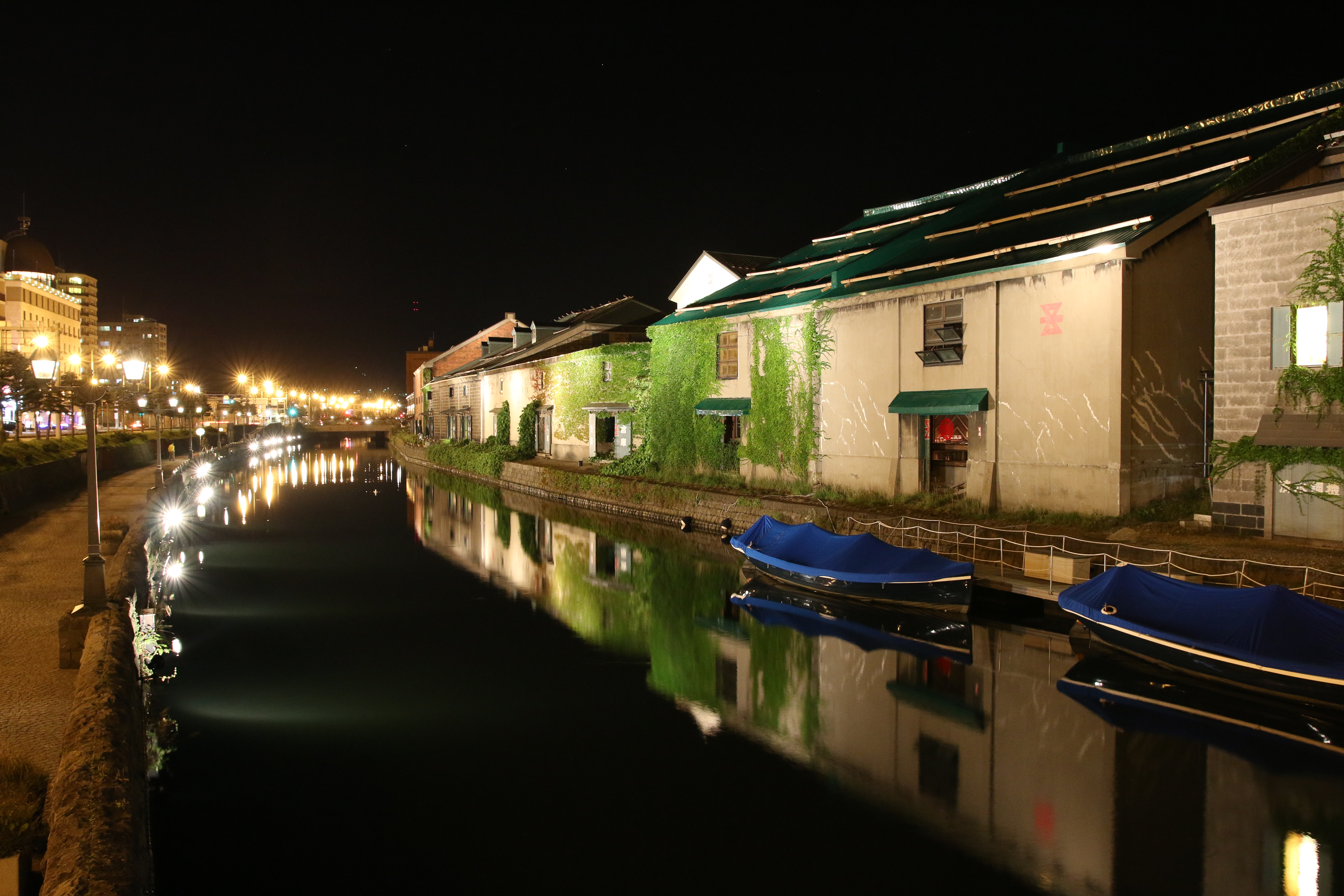 北海道小樽の歴史的建造物である倉庫群と運河。水面の揺らぎによるボートのブレを避けるためにISO1600まで感度を上げてシャッタースピード0.6秒で撮影した。高感度撮影だが驚く程にノイズも少なく、またノイズリダクションによる被写体のデティール崩れも見られない。オートホワイトバランスによる色味も好ましい。SIGMA 18-35mm F1.8 DC HSM / 1/1.7秒 / F5 / 0EV / ISO1600 / マニュアル / WB：オート / 18mm