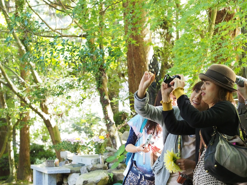 ここでは、山本まりこさんが前ボケの作り方をレクチャーしてくれました。透過光で透ける木々にピントを合わせた状態で、山本まりこさんがレンズの前に落ち葉をかざすときれいな前ボケが！　前ボケがきれいに撮れるたび、参加者からは歓声があがっていました。前ボケを作るコツは、レンズを望遠側に設定し、ピントを合わせる被写体とレンズの前に配置する被写体の距離を離すこと。