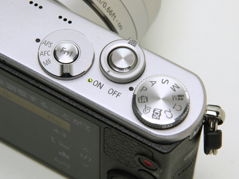上面に並ぶダイヤル。左からAFモードダイヤル（中央はFnボタン。各種機能を割り当て可）、シャッターボタンと電源レバー、モードダイヤル