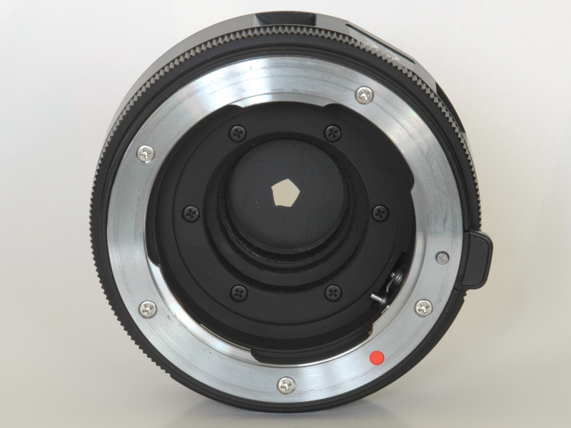 アダプターをKマウント側から見たところ。赤丸の指標のすぐ近くに絞り込みレバーが、また奥にレンズシャッターの羽根が見える。こちら側に電気接点がないところをみると、レンズからは何も情報を取得していないようだ。