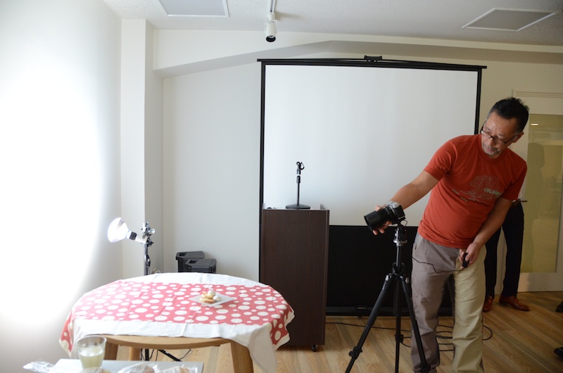 質問で多かったのが「夜ごはんを撮影するときはどうすればいいですか？」というもの。蛍光灯や電球の光では色がかぶってしまうので室内の明かりをすべて消し、太陽光に近いブルーランプを使うのがオススメだそうです。ブルーランプとソケットは合わせて5,000円程度。光源を壁側に向けることで、人工的な逆光が作れ、光もやわらかくなります。