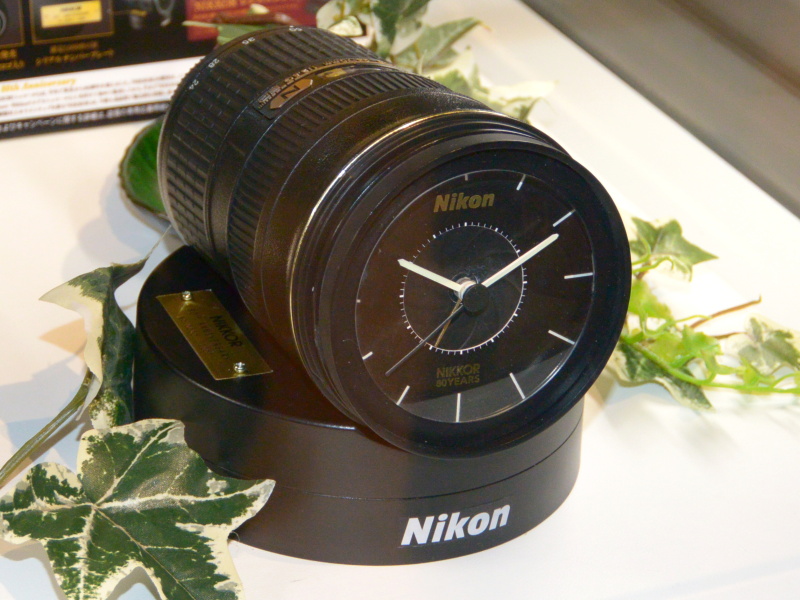 NIKKOR80周年記念の第3弾で進呈する「NIKKORレンズクロック」。対象レンズを購入した中から抽選で1,000名に贈る。フォーカスモードスイッチがアラームのオン/オフになっており、アラーム音はD4のシャッター音を忠実に再現したという。
