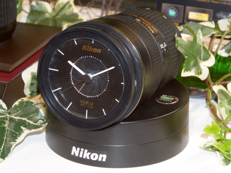 NIKKOR80周年記念の第3弾で進呈する「NIKKORレンズクロック」。対象レンズを購入した中から抽選で1,000名に贈る。フォーカスモードスイッチがアラームのオン/オフになっており、アラーム音はD4のシャッター音を忠実に再現したという。
