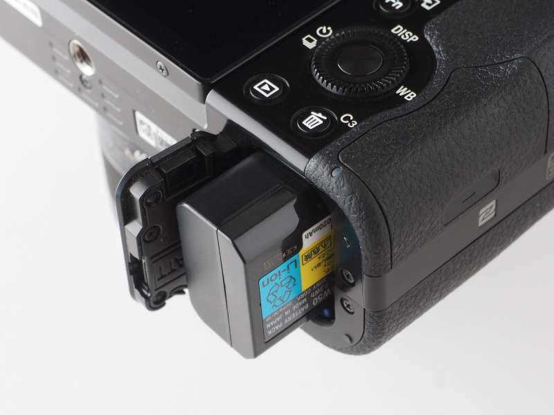 バッテリー室はカメラ底面にある。バッテリーは「NP-FW50」が1個付属。本体内充電用のACアダプターとマイクロUSBケーブルが付属しており、バッテリーチャージャーは別売。