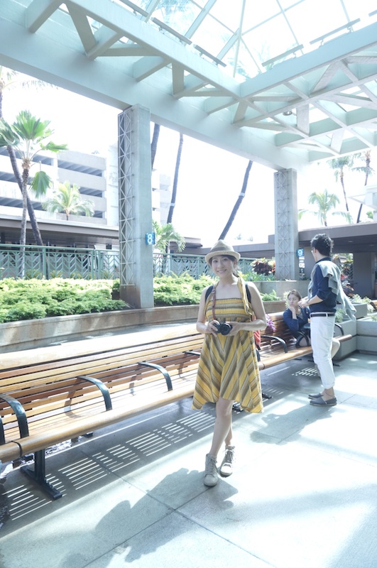 ハワイ到着直後の空港で1枚♪ 山本さんの撮影スタイルは、日焼け対策用の帽子と歩きやすいスニーカーは必需品。服は撮影場所に合って自分のテンションも上がるものをチョイスするそうです。ハワイでは、涼しげでカラフルな南国風のワンピースで撮影していました。