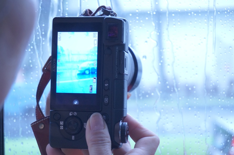 空港を出た途端、激しいスコールが。バスの中から雨で霞むハワイの町並みを山本さんの色で撮影していました。