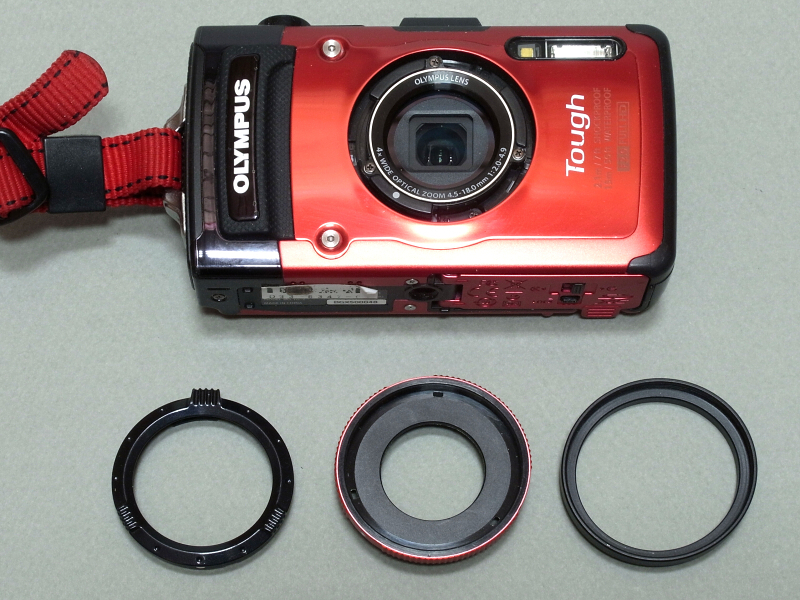 TG-2にもちょっと工夫が必要なのだが、レンズ周囲に装着されているリングを外し（左）、純正のアダプターリング（中）と40.5→43mmのステップアップリング（右）を装着する。