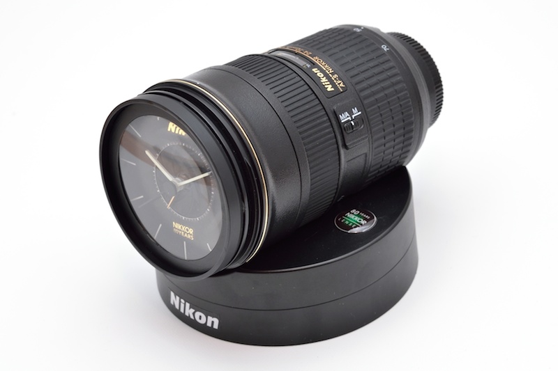 専用スタンドに置いた「NIKKOR レンズクロック」。アラーム音はD4のシャッター音なので、これを聞きたいがために寝坊してしまわないように。「隣のカメラマンのほうがショット数が多くてドキドキする夢」を見たりして