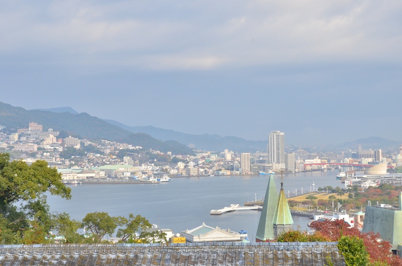 祈念坂を登りきると、大浦天主堂越しで長崎の町並みを望むことができました。撮影していると、白いフェリーが港に入ってくるところでした。