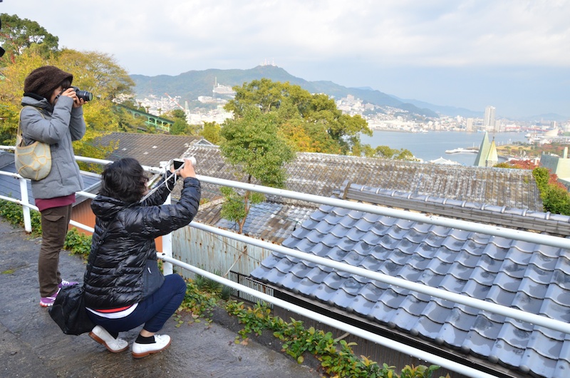 祈念坂を登りきると、大浦天主堂越しで長崎の町並みを望むことができました。撮影していると、白いフェリーが港に入ってくるところでした。