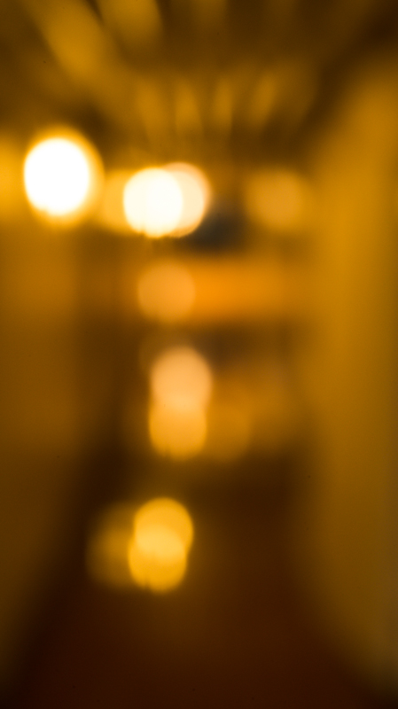 穴あきパンチであけた3mmの穴で撮影。見ればおわかりの通り、客船の廊下で撮影した。上部に写っているのは天井の配管。ニコンD600