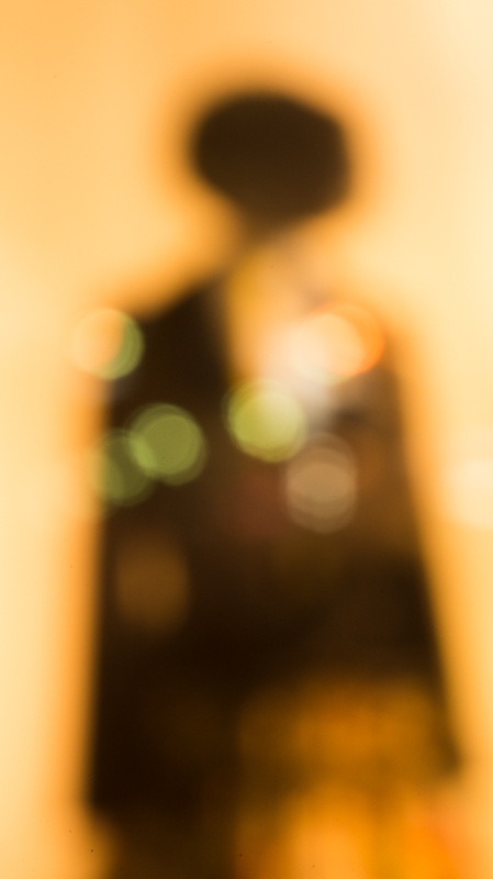 3mmホールカメラ。ショーウインドウのマネキン。街角の灯りがガラスで反射して、丸いボケになっている。ニコンD600