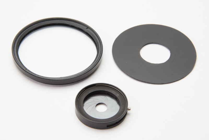左上：52mmのフィルターの枠。右上：ドーナッツ型にサークルカッターで切ったポリプロピレンシート。下：虹彩絞りユニット/muk i30mm