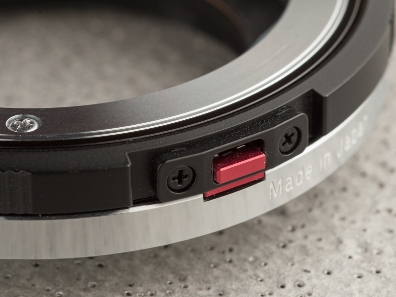 フォーカスリングに赤いスイッチがある。このスイッチを下に押し込むと、ヘリコイドの動きをロックできる