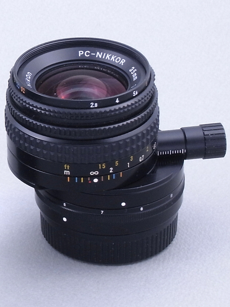 こちらはPC-Nikkor 35mm F2.8<new class="">だが、一見ごく普通のレンズと変わらない外観だ。しかし最大の11mmにシフトすると、素人目には“壊れたレンズ”に見えるかも知れない（笑）。レンズ構成は7群8枚で、こちらも特殊レンズは使われていない。ニコンは1962年7月に、ライカ判カメラ用として世界初のアオリレンズ「PC-NIKKOR 35mm F3.5」を発売しており、このレンズはその改良版だ。</new>