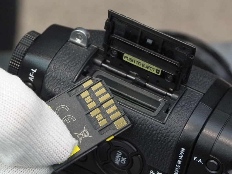 X-T1のカードスロットは側面。高速転送規格のUHS-IIに対応する（カードの接点が2列に増えている）。RAW+JPEGで8コマ/秒の連写を行なっても、連写速度が落ちるまで20コマ以上撮れた。全画像の書き込みが終わる前から、ある程度の枚数を遡ってプレビューできる