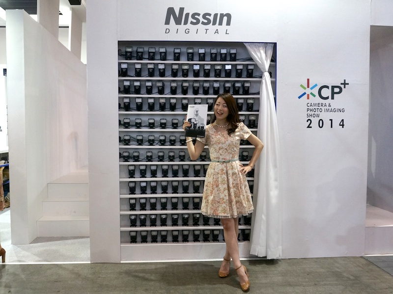 壁面に並べられたストロボの前にモデルが立つ