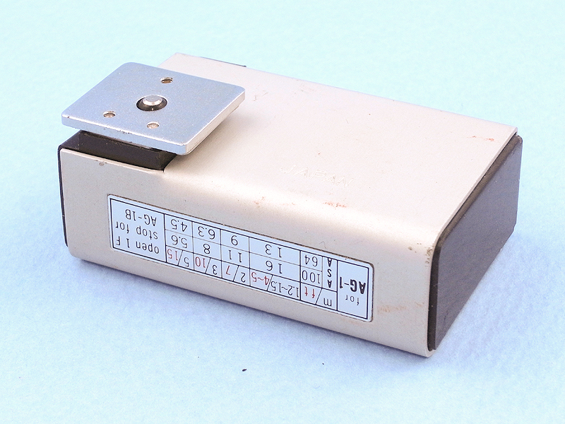 PEN-FLASHは現在のストロボと同じくホットシューに装着するタイプだ。調べてみると、PENシリーズで初めてホットシューを装備した「OLYMPUS PEN EED」と同時期の1967年発売のようだ。背面には露出表が印刷され、距離に応じた絞り値が示されている。対応フィルム感度は「ASA64/100」である。