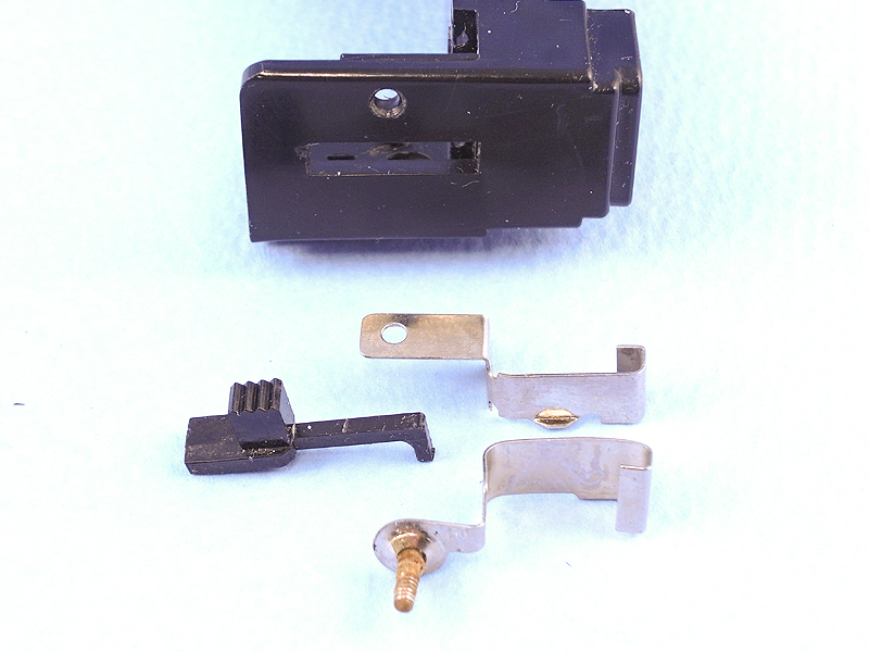 電池レイアウトが決まったところで、電源スイッチについて考えてみる。ご覧の部品はフラッシュバルブ装着金具と排出レバーだが、これをスイッチ金具として流用するアイデアが閃いた。